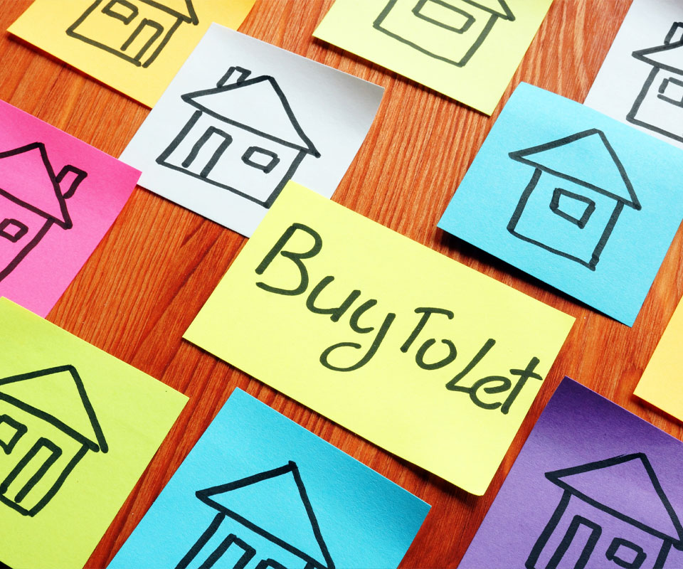 Image showing colorful sticky notes on a table with houses drawn on them and the words "Buy To Let" written on one