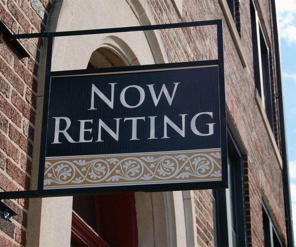 Image showing the side of a building with a sign saying "Now Renting"