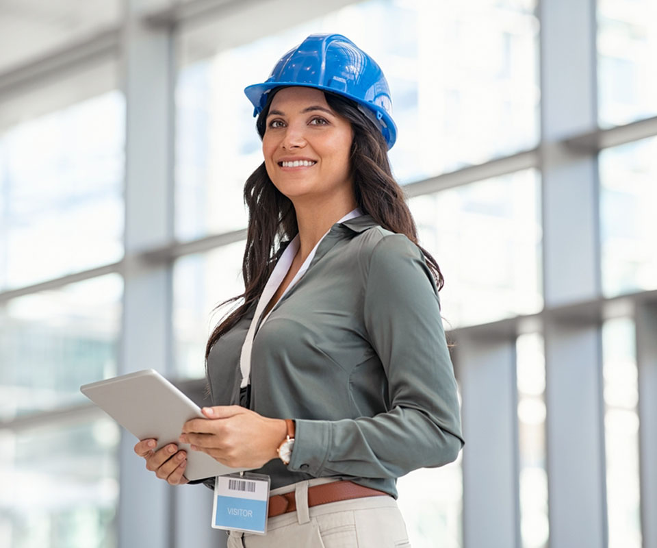 Image showing a woman in a hardhat holding a tablet on a building site