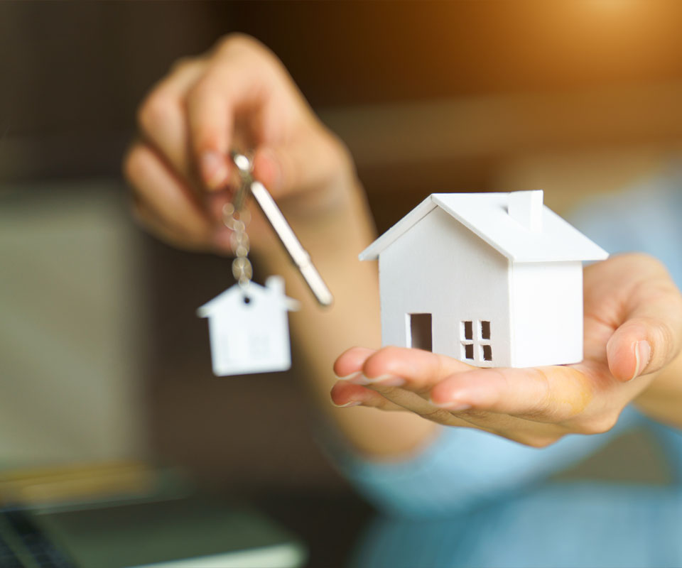 Image showing a close up of a woman's hands holding a model house and a set of house keys