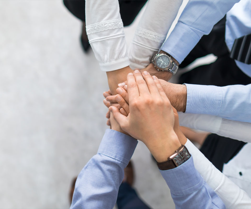 Image showing a close up overhead view of a group of business people with their hands on top of each other's