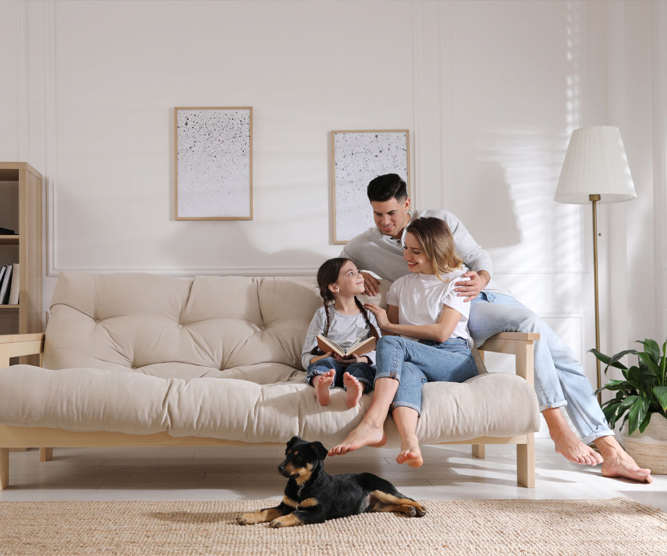 Image showing a family sitting on the sofa reading together with their dog on the floor in front