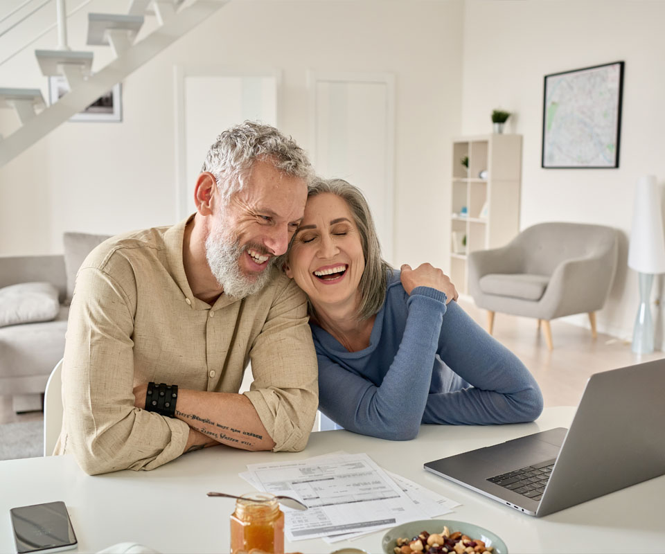 Image showing an older couple smiling while looking at a laptop together