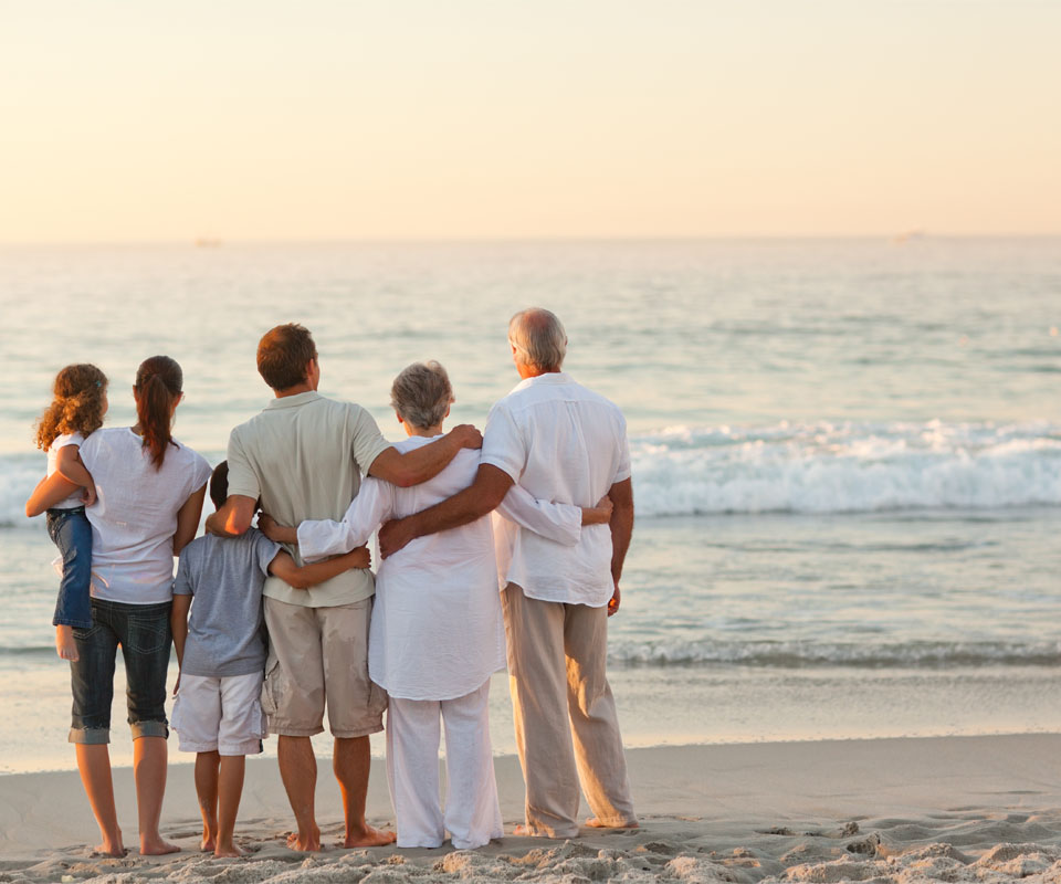 Image showing a family of three generations looking out over the sea at sunset