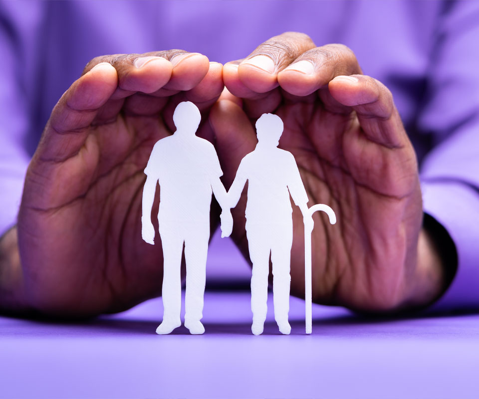 Image showing a paper cut out of an elderly couple being protected by a pair of hands