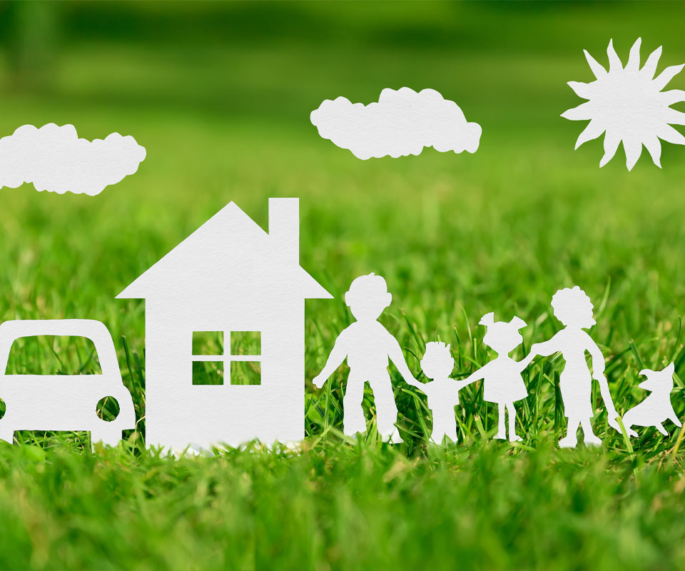 Image showing paper cut outs of a family with their house and car in the grass