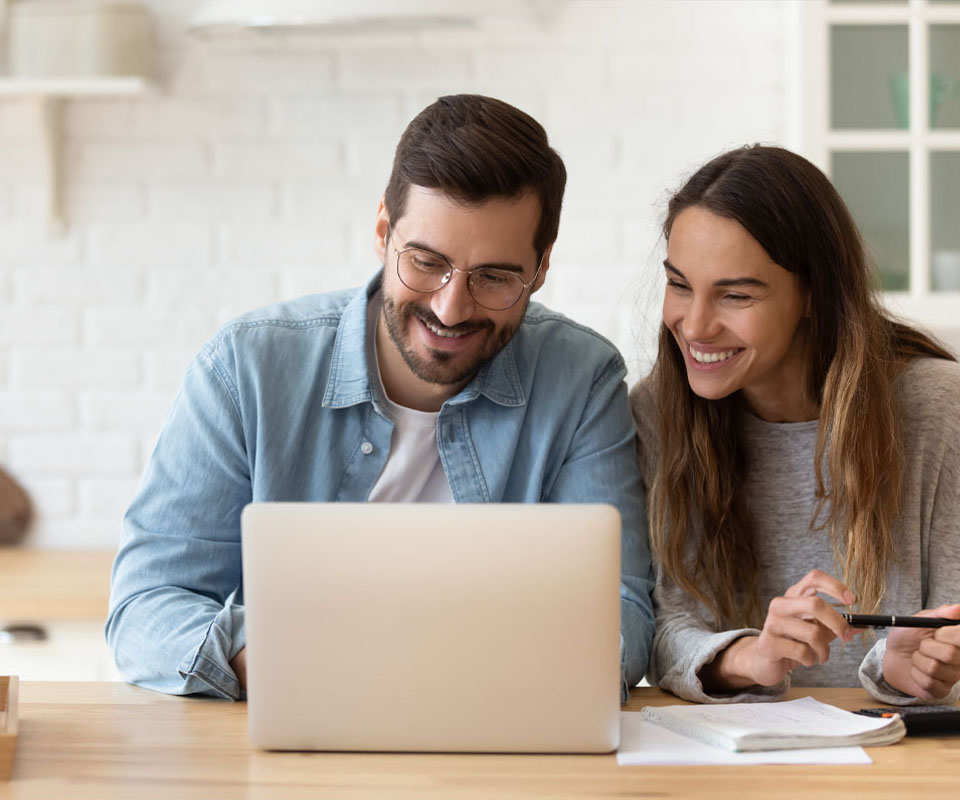 Image showing a smiling young couple looking at a laptop together