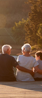 Image showing a couple with their grandchildren sitting on a dock by a lake