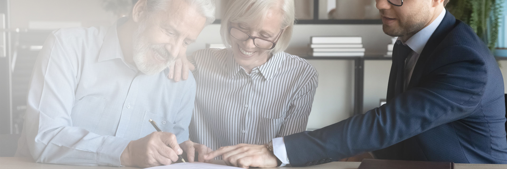 Image showing a happy retired couple in a meeting with an adviser, signing a document