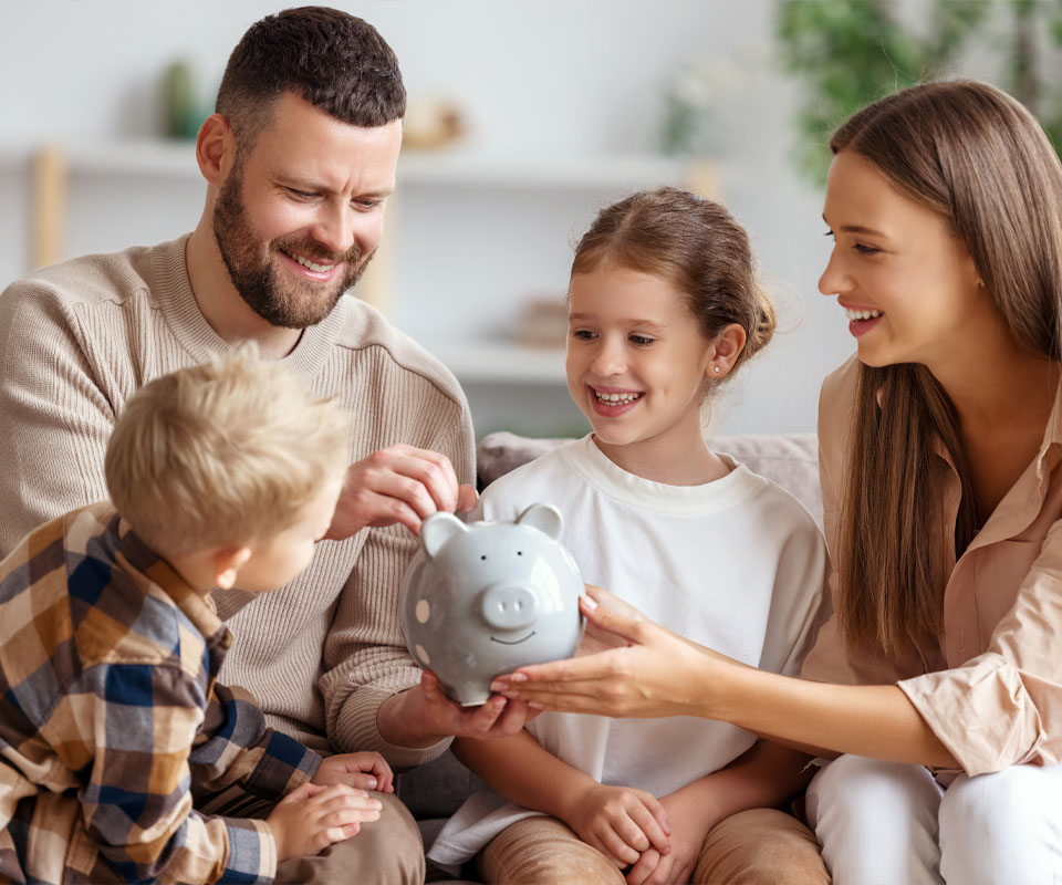 Image showing a happy family putting some money in a piggy bank