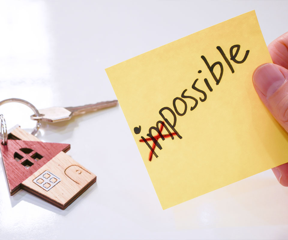Image showing a sticky note next to some house keys with the word "Impossible" written on it and "Im" crossed out so it reads "Possible"