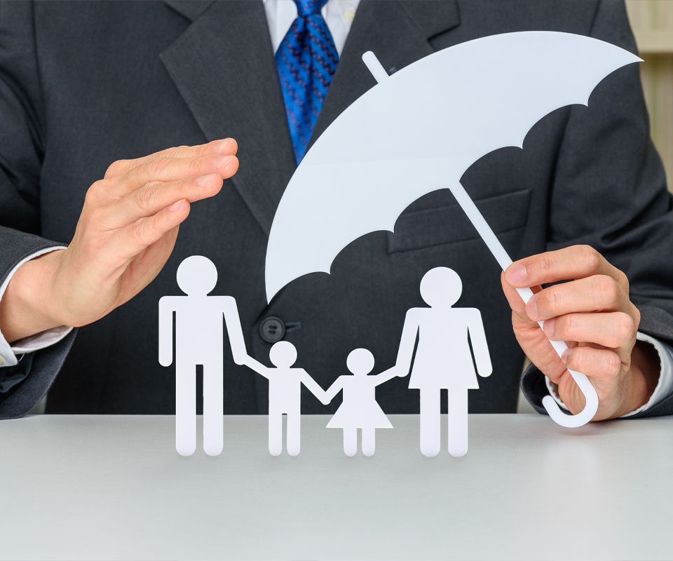 Image showing a business man holding a paper umbrella over a paper cut out family