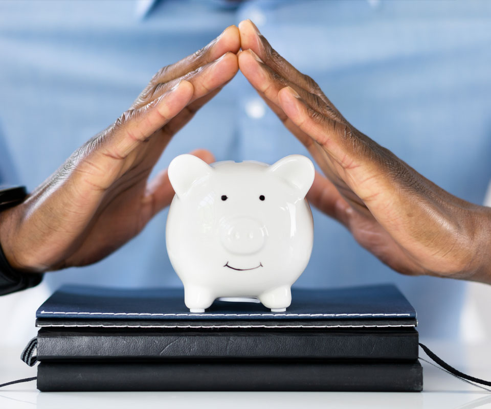 Image showing a business man holding his hands over a piggy bank
