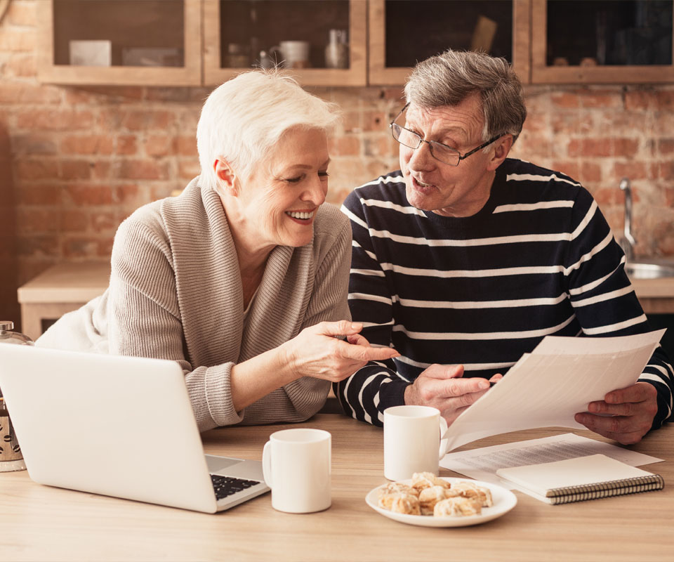 Image showing an older couple looking at some paperwork and a laptop together