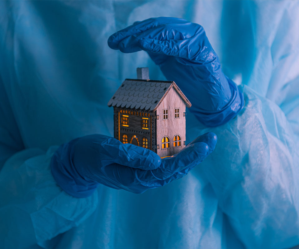 Image showing a close up of a medical professional in surgery clothes holding a model house