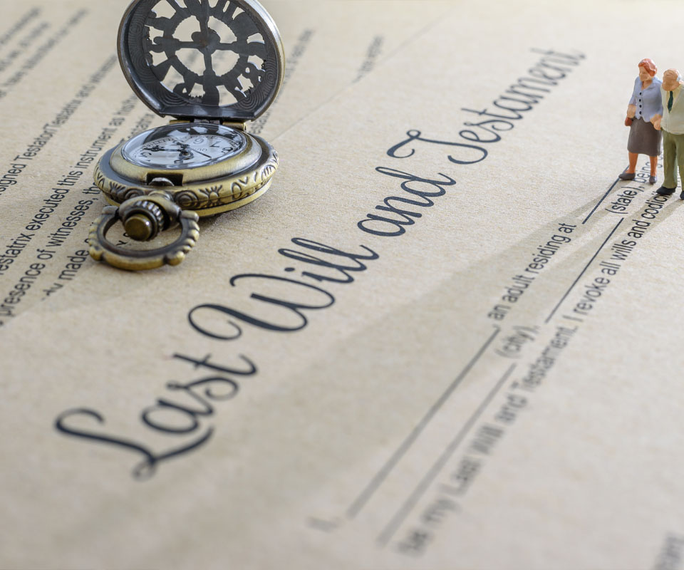 Image showing a model of an elderly couple walking across a will document with a pocket watch on top of it