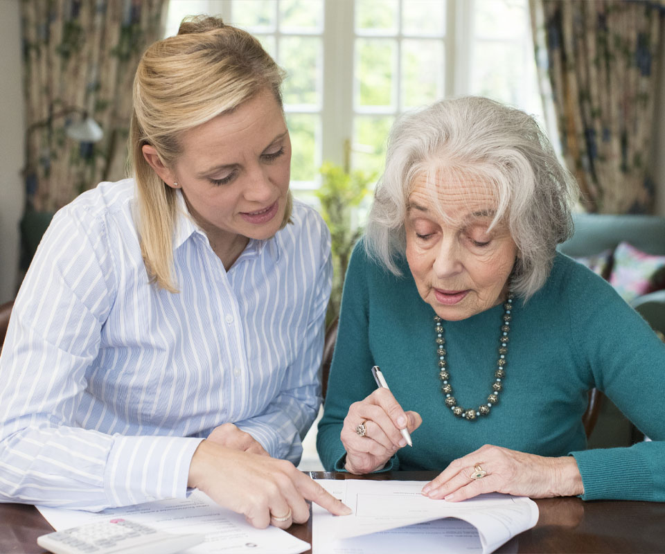 Image showing a young woman helping an elderly woman with some paperwork