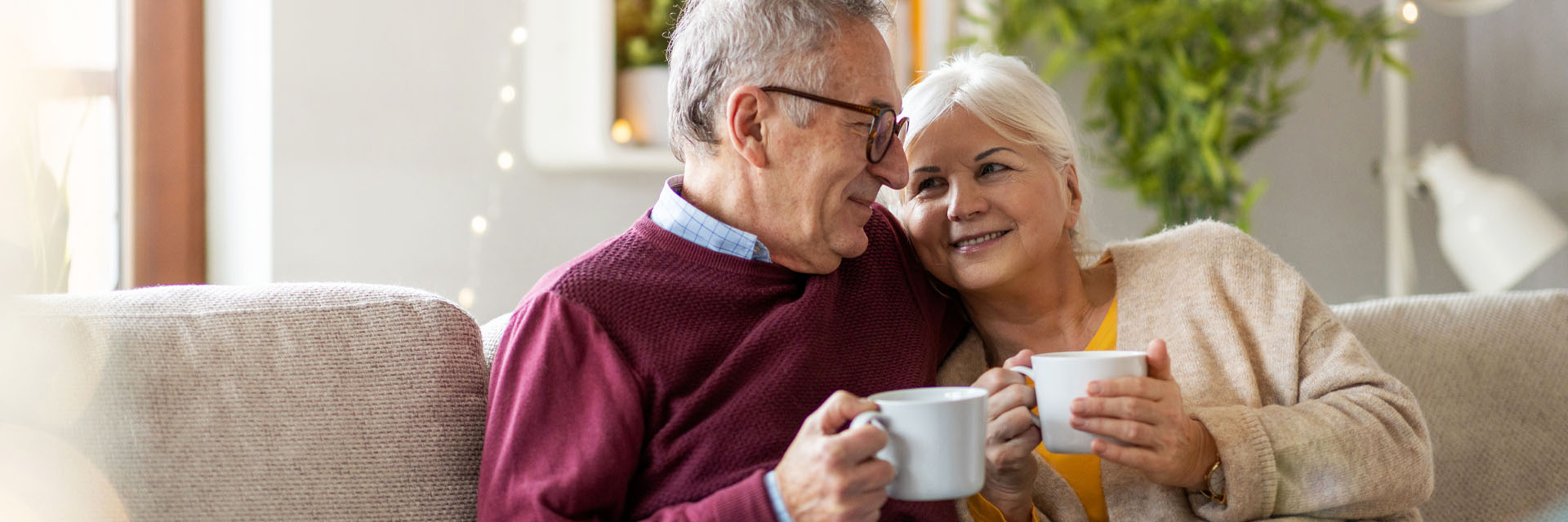 Image showing an older couple cuddled on the sofa with a hot drink