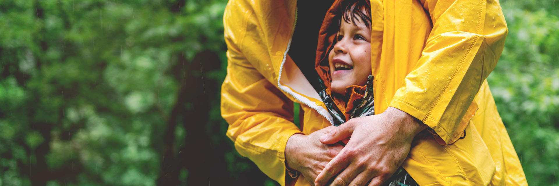 Image showing a Dad covering his son with his raincoat